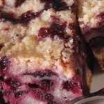 Slice of blueberry coffee cake with homemade blueberry pie filling and simple glaze on a white background