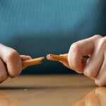 Angry female employee breaking pencil in anger
