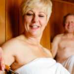 woman and man sitting in sauna to lower blood pressure