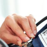 Doctor measuring patient's blood pressure to diagnose different types of hypertension