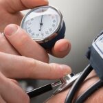 Doctor checking patients blood pressure
