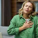woman having a panic attack while sitting on a couch