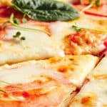 a pizza with tomatoes and basil on top