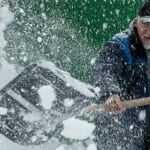 Man shoveling snow in driveway